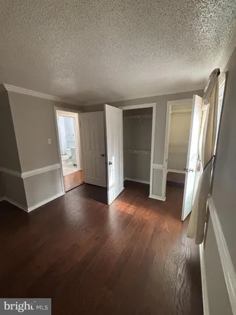 an empty room with wooden floor and closet