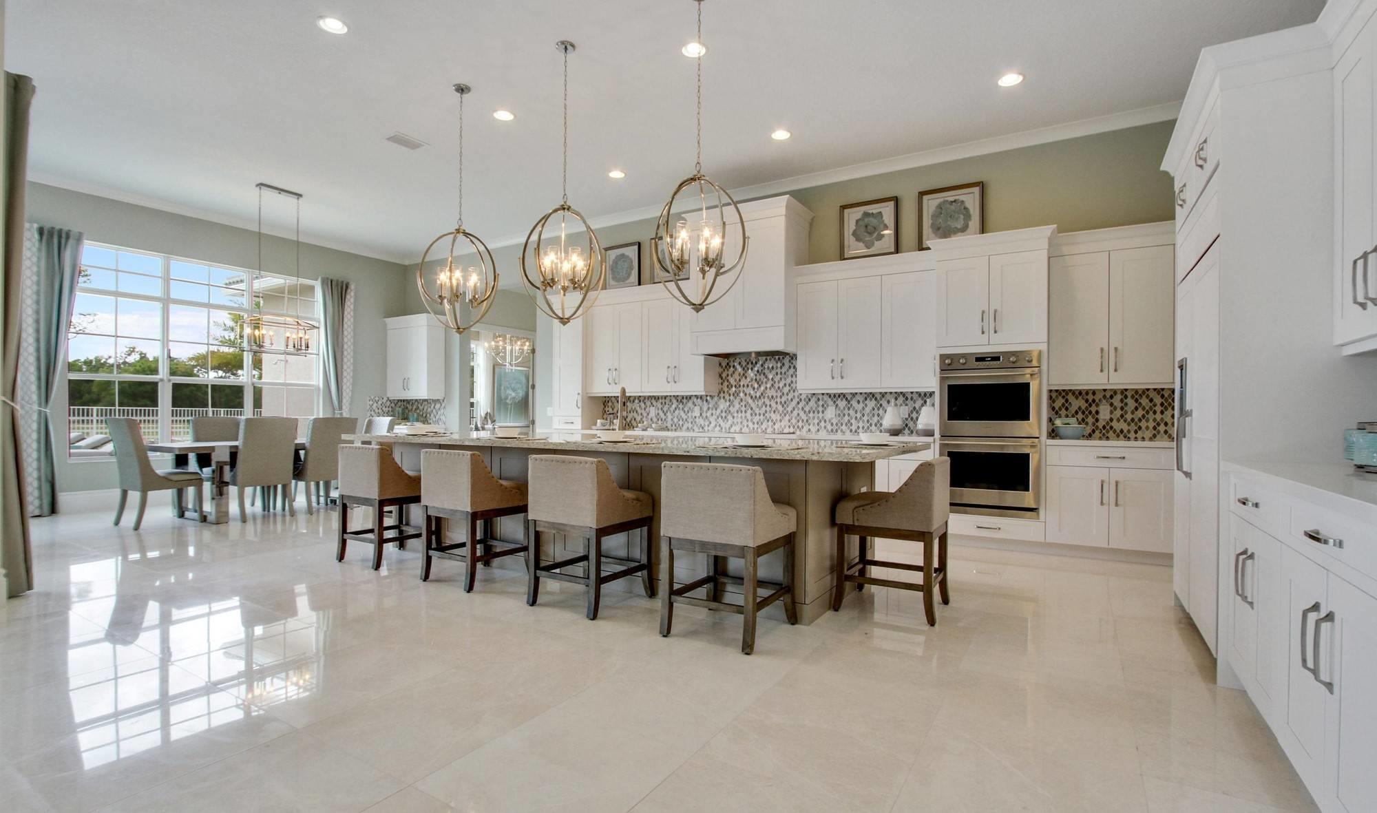 a large kitchen with cabinets chairs and a chandelier