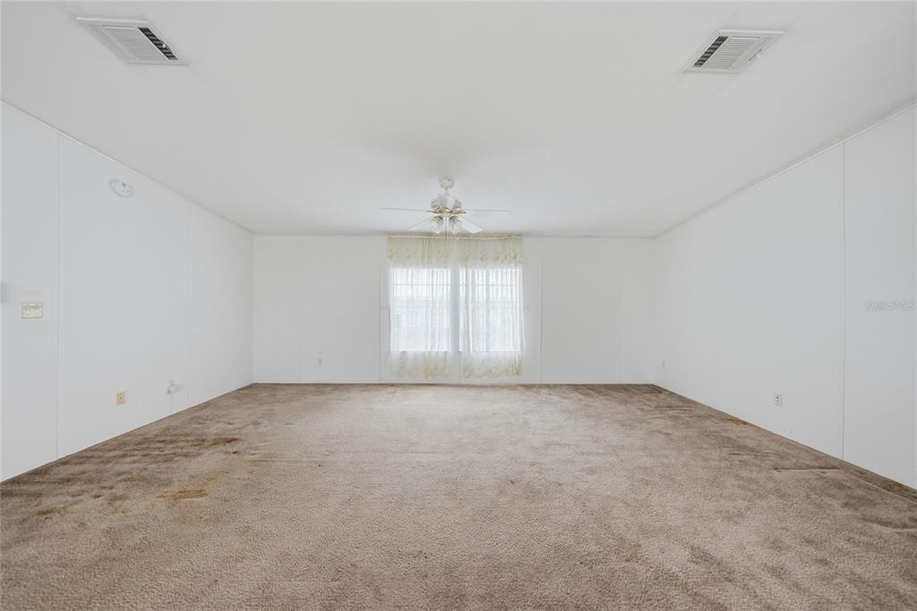 11923 Southwest Loop Terrace Arcadia, FL 34269 - Photo 17 of 50 an empty room with chandelier fan and windows