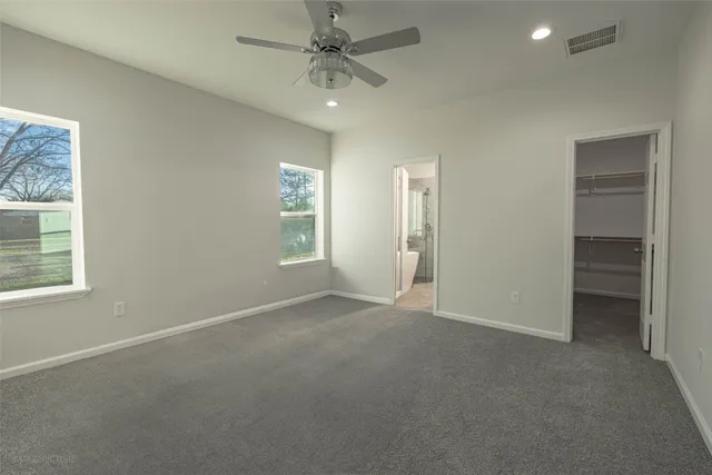 an empty room with windows and fan