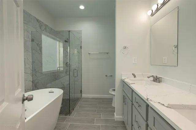 a bathroom with a granite countertop sink a toilet and shower