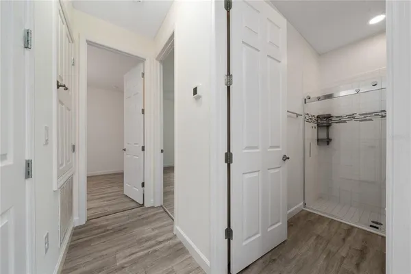 an empty room with wooden floor ceiling fan and window