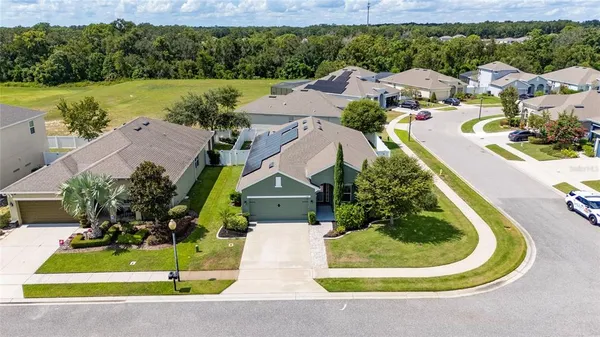 an aerial view of a house with a yard and lake view