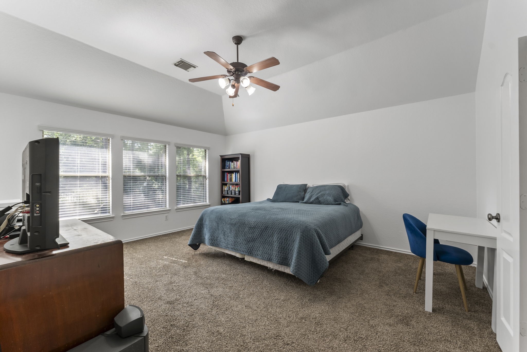 2106 Leaf Meadows Court Spring, TX 77386 - Photo 25 of 34 a spacious bedroom with a bed and a chandelier