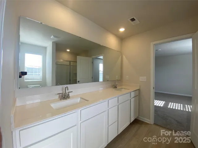 a bathroom with a double vanity sink and a mirror