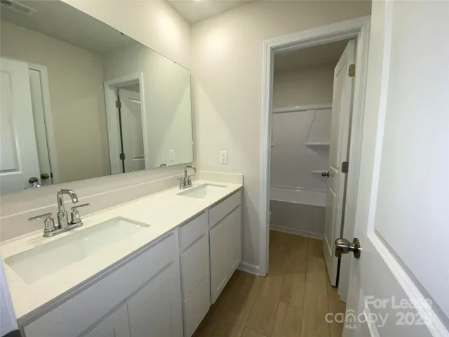 a bathroom with a double vanity sink mirror and shower
