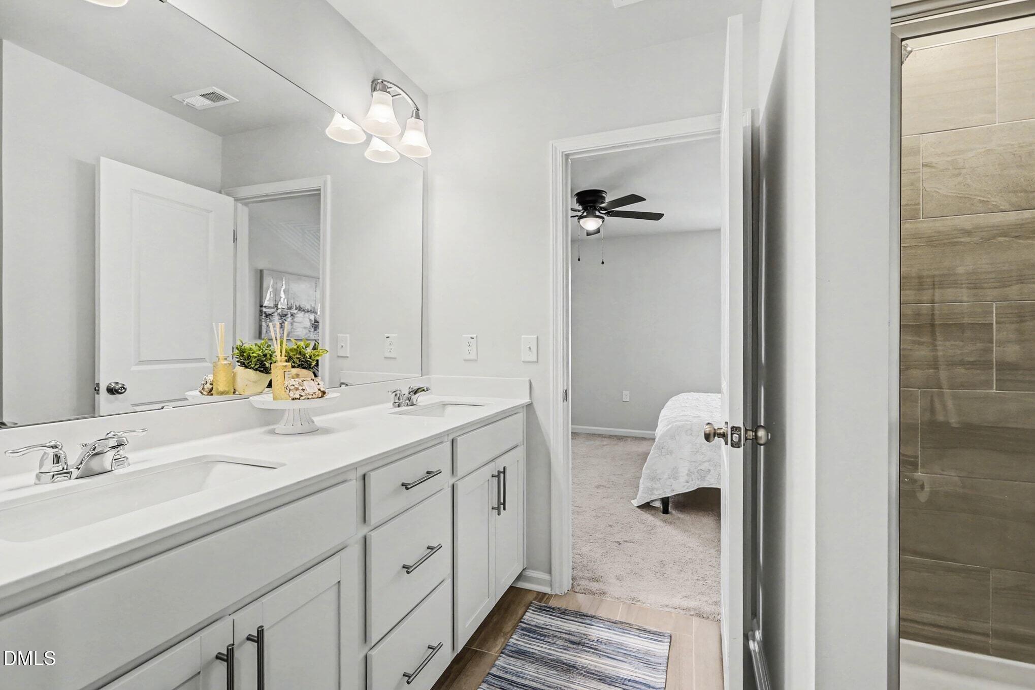 2528 Chert Lane Raleigh, NC 27610 - Photo 18 of 44 a spacious bathroom with a double vanity sink a mirror and a shower