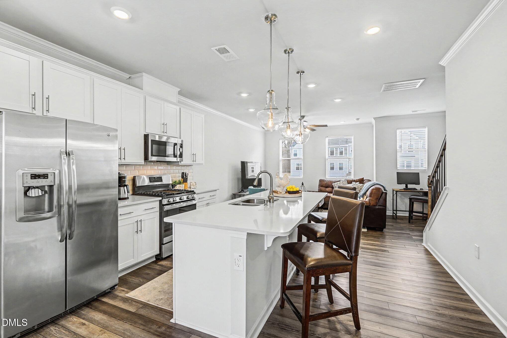 2528 Chert Lane Raleigh, NC 27610 - Photo 4 of 44 a kitchen with stainless steel appliances a dining table chairs stove and refrigerator