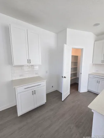 a kitchen with white cabinets and sink