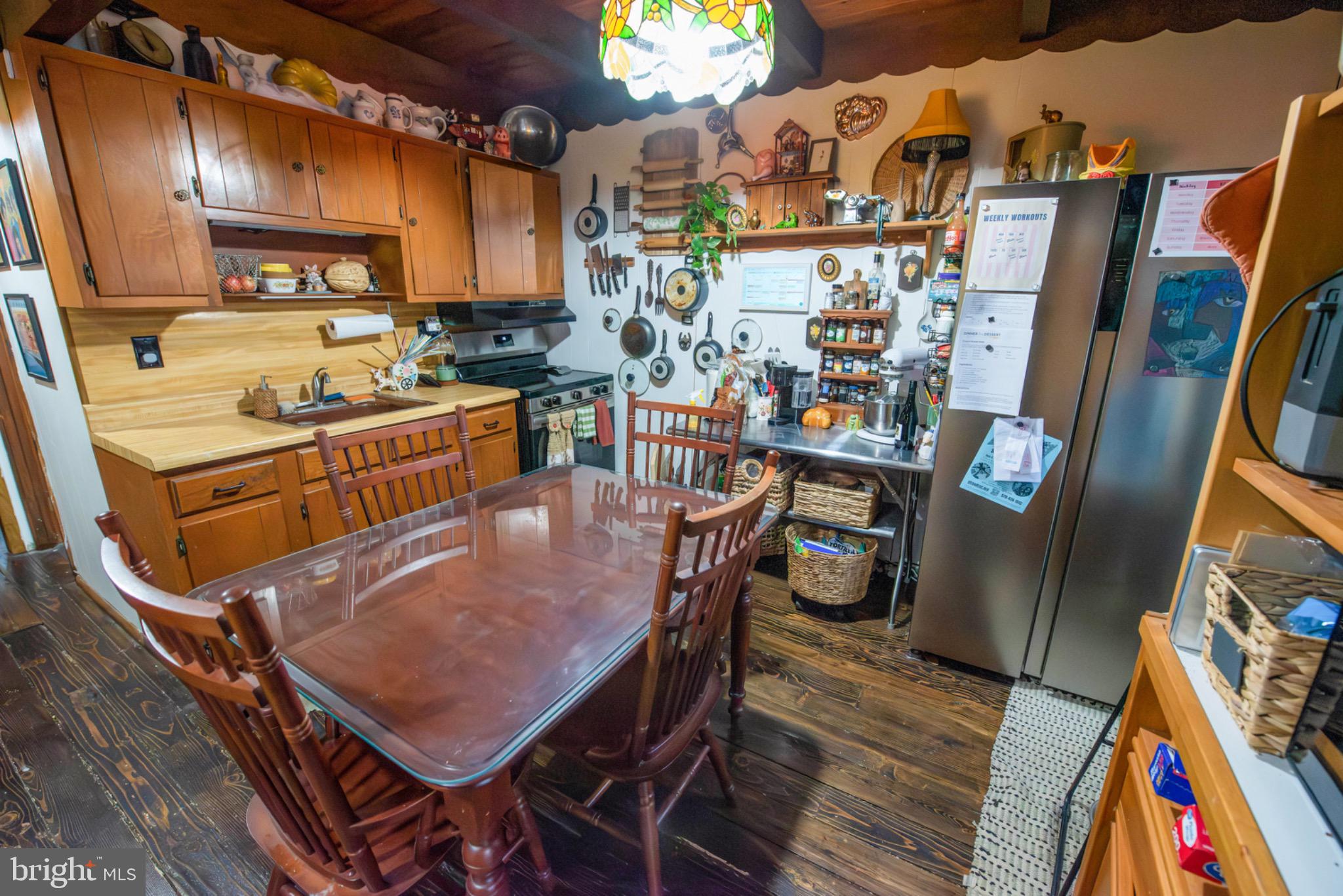 117 Swallow Circle Bushkill, PA 18324 - Photo 12 of 47 a room with stainless steel appliances kitchen island granite countertop a refrigerator a stove a sink and a dining table with wooden floor