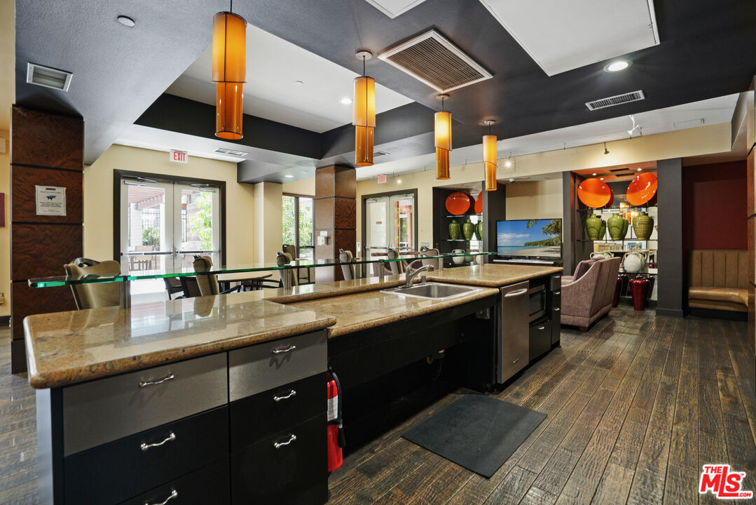 100 South Alameda Street, Unit 308 Los Angeles, CA 90012 - Photo 27 of 30 a kitchen with lots of counter top space and stainless steel appliances
