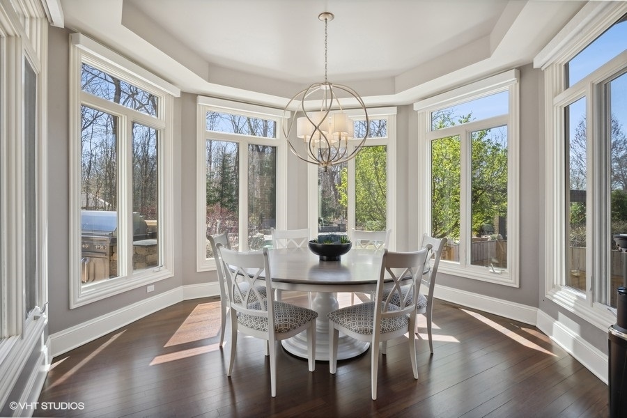 627 Alberosky Way Batavia, IL 60510 - Photo 17 of 73 a dining room with wooden floor a chandelier a glass table and chairs
