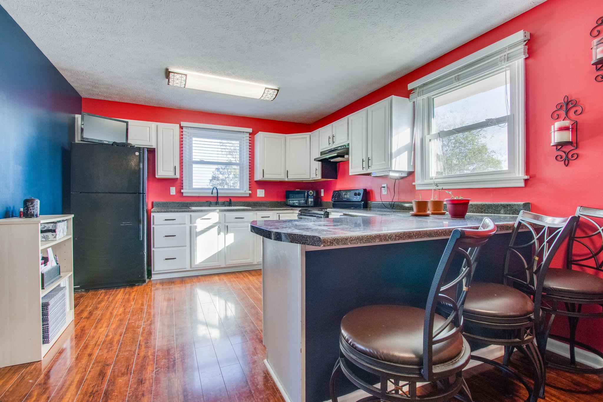 580 Curd Road Mount Juliet, TN 37122 - Photo 8 of 17 a kitchen with stainless steel appliances granite countertop a stove a refrigerator a sink dishwasher a dining table and chairs with wooden floor