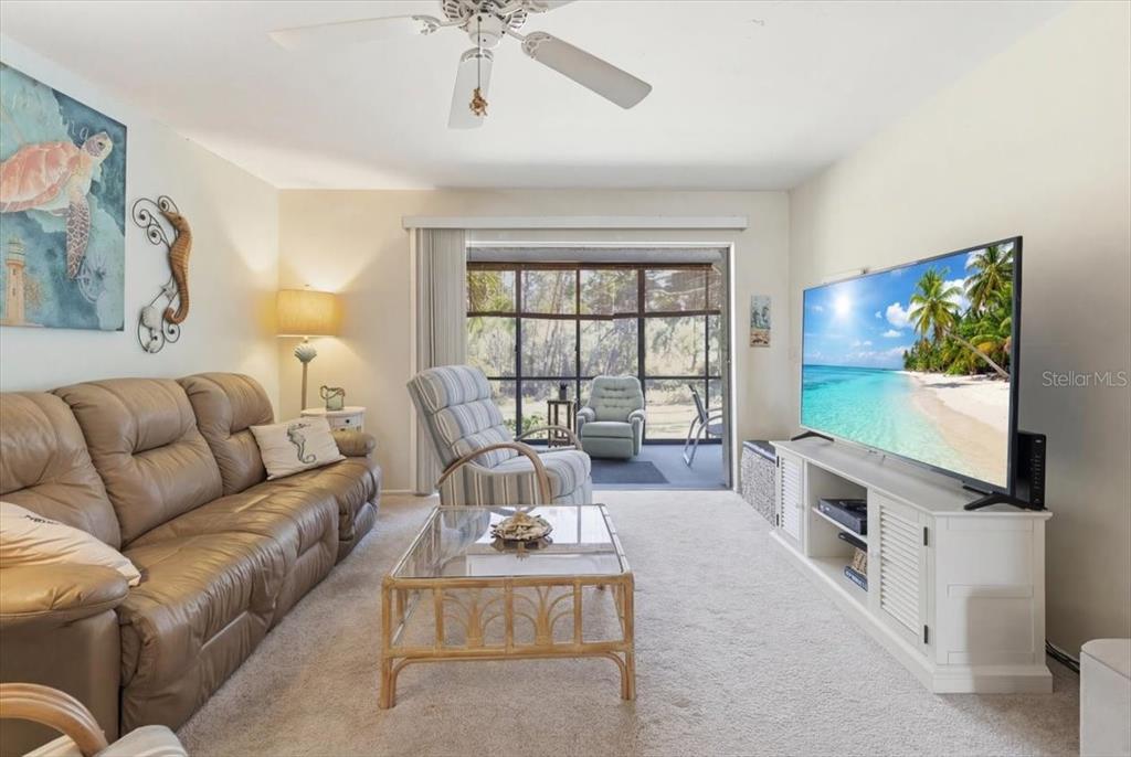 6800 Placida Road, Unit 192 Englewood, FL 34224 - Photo 12 of 33 a living room with furniture flat screen tv and a large window