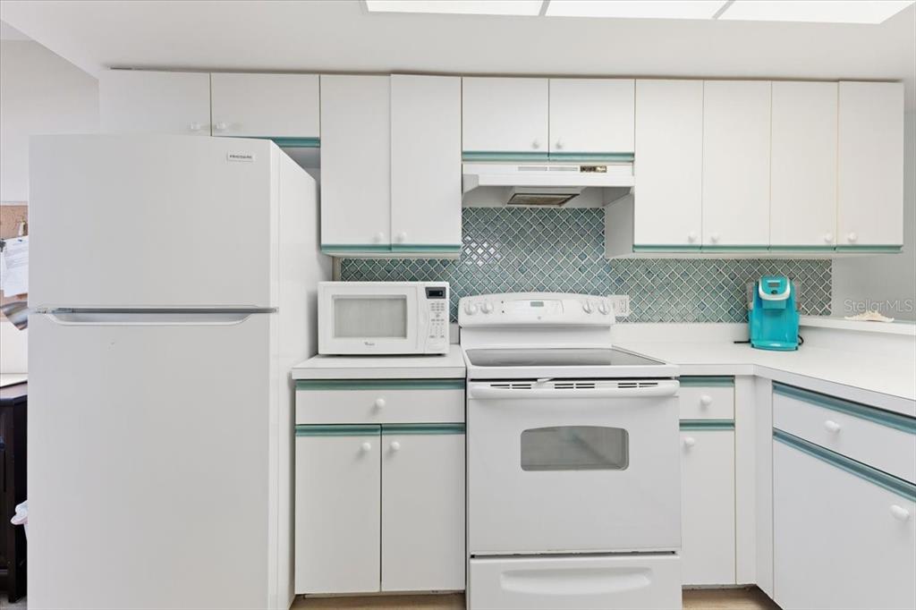 6800 Placida Road, Unit 192 Englewood, FL 34224 - Photo 5 of 33 a kitchen with stainless steel appliances white cabinets and a refrigerator