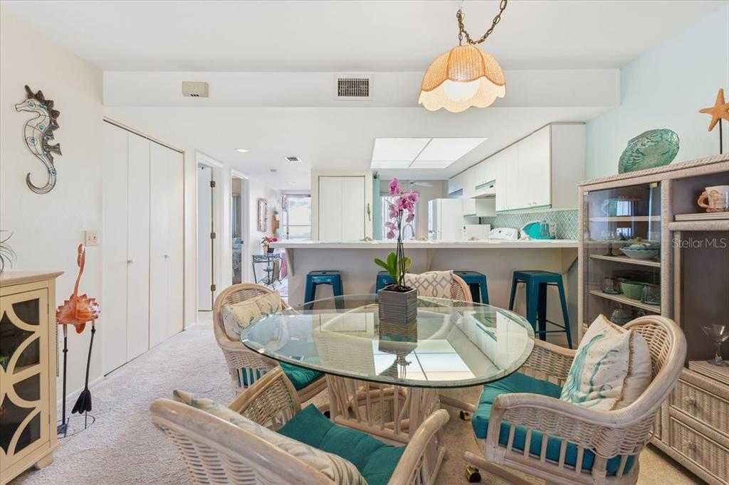 6800 Placida Road, Unit 192 Englewood, FL 34224 - Photo 10 of 33 a dining room with furniture a rug a potted plant and a chandelier