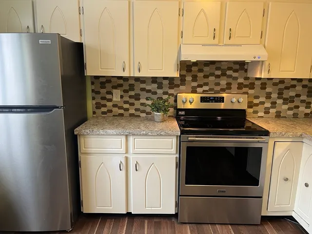 a kitchen with granite countertop white cabinets and stainless steel appliances