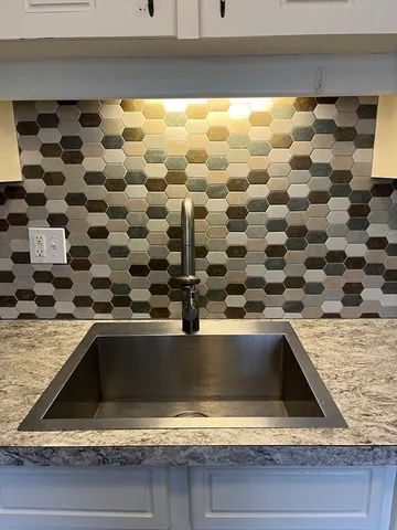 a kitchen with a wooden floor and white cabinets