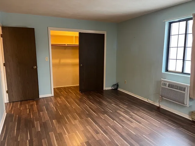 an empty room with wooden floor and closet