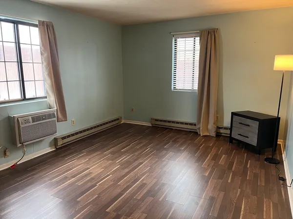 a view of a room with wooden floor and a window