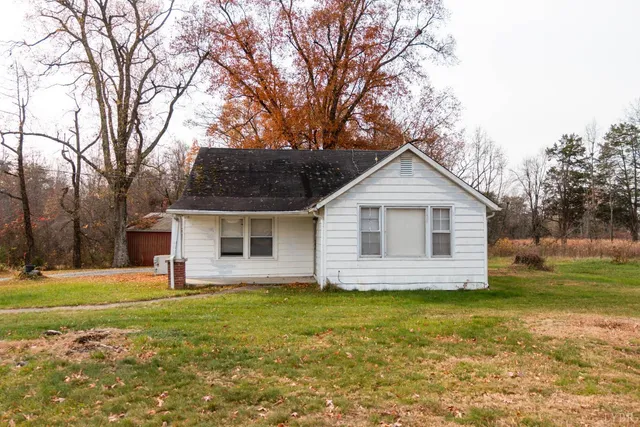 a front view of house with yard and trees around