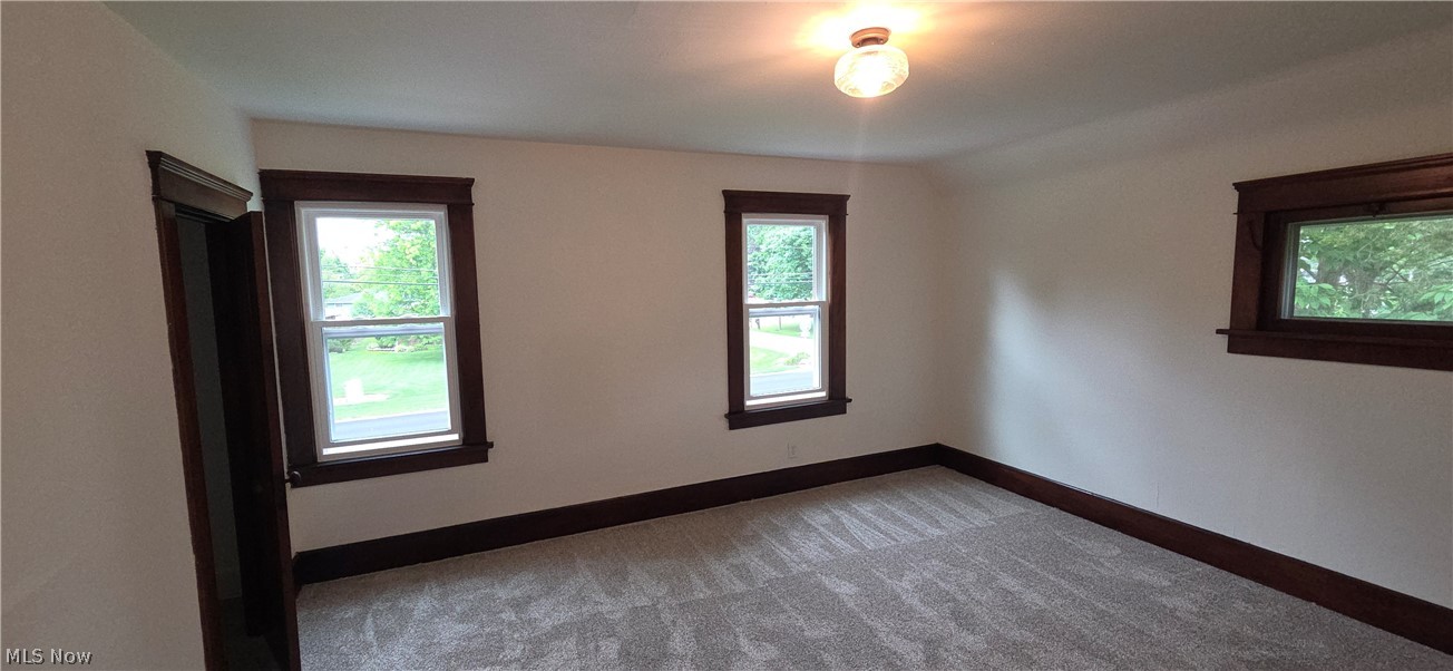 9964 East River Road Elyria, OH 44035 - Photo 24 of 45 Spacious room featuring light-colored walls, original dark wood trim, and a semi-flush mount ceiling fixture