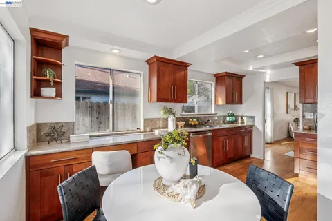 a dining room with furniture a kitchen view and wooden floor