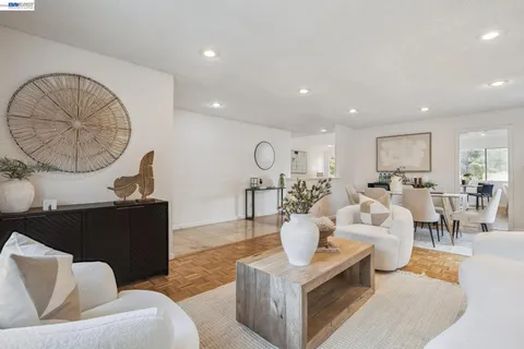 a living room with furniture a table and kitchen view