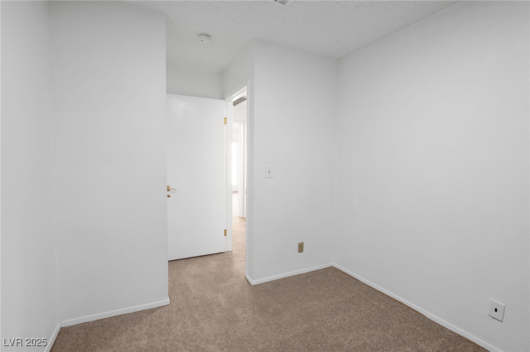 7030 Burcot Avenue, Unit F108 Las Vegas, NV 89156 - Photo 14 of 18 Spare room with carpet flooring and a textured ceiling