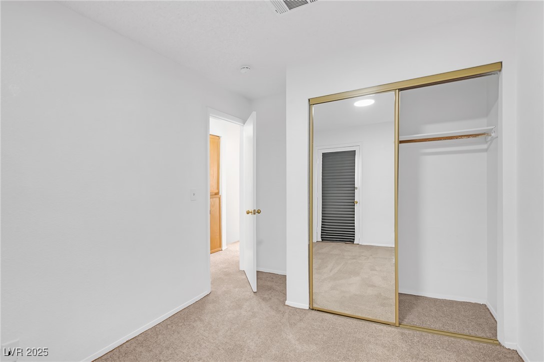 7030 Burcot Avenue, Unit F108 Las Vegas, NV 89156 - Photo 15 of 18 Unfurnished bedroom with light colored carpet and a closet