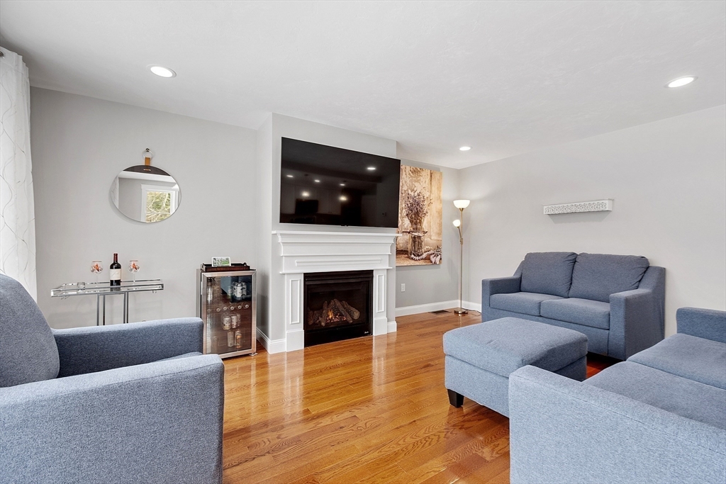 4 Scotch Pine Farm Way, Unit 1 Pepperell, MA 01463 - Photo 11 of 35 a living room with furniture a fireplace and a flat screen tv