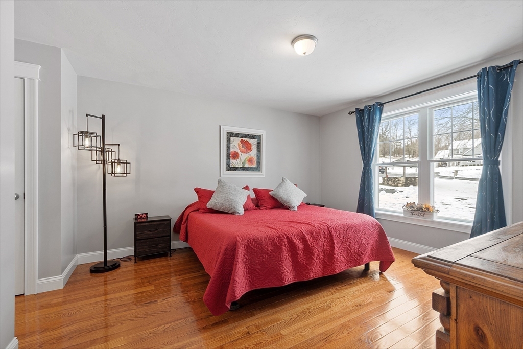 4 Scotch Pine Farm Way, Unit 1 Pepperell, MA 01463 - Photo 16 of 35 a bedroom with a bed and a large window