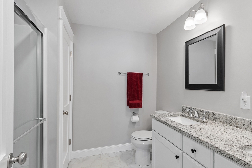 4 Scotch Pine Farm Way, Unit 1 Pepperell, MA 01463 - Photo 18 of 35 a bathroom with a granite countertop toilet sink and mirror