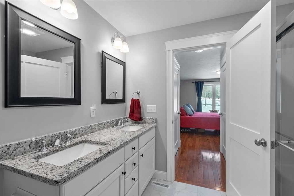 4 Scotch Pine Farm Way, Unit 1 Pepperell, MA 01463 - Photo 19 of 35 a en suite bathroom with a granite countertop sink and a mirror