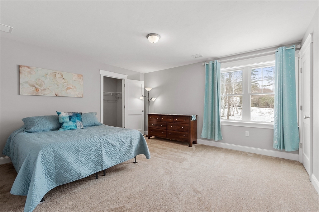 4 Scotch Pine Farm Way, Unit 1 Pepperell, MA 01463 - Photo 21 of 35 a spacious bedroom with a bed and a cabinets