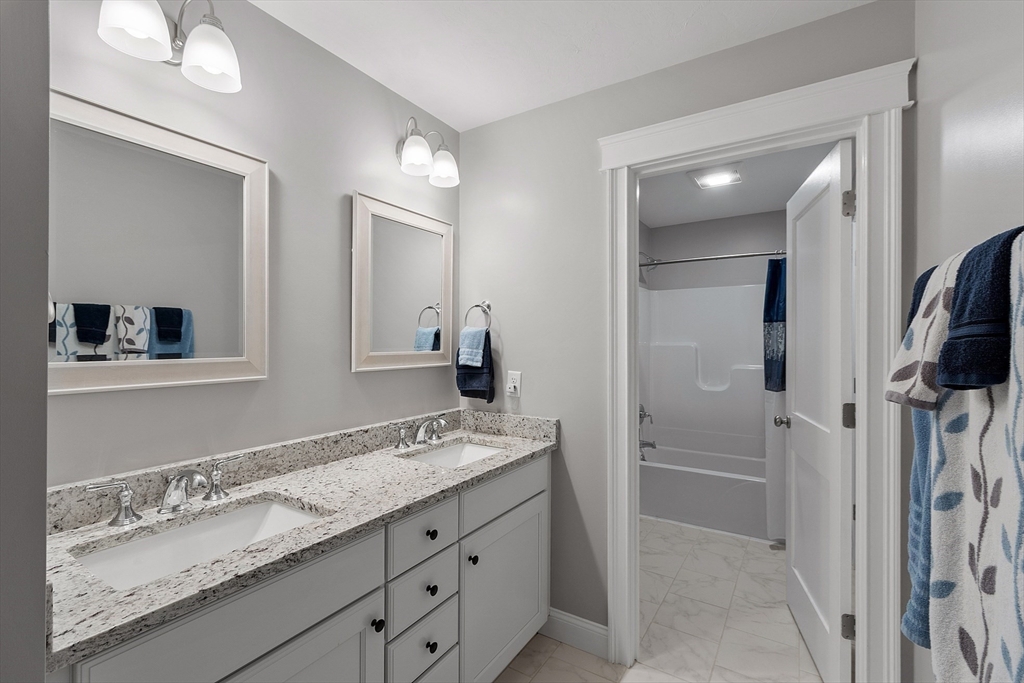 4 Scotch Pine Farm Way, Unit 1 Pepperell, MA 01463 - Photo 27 of 35 a bathroom with a granite countertop double vanity sink mirror and shower