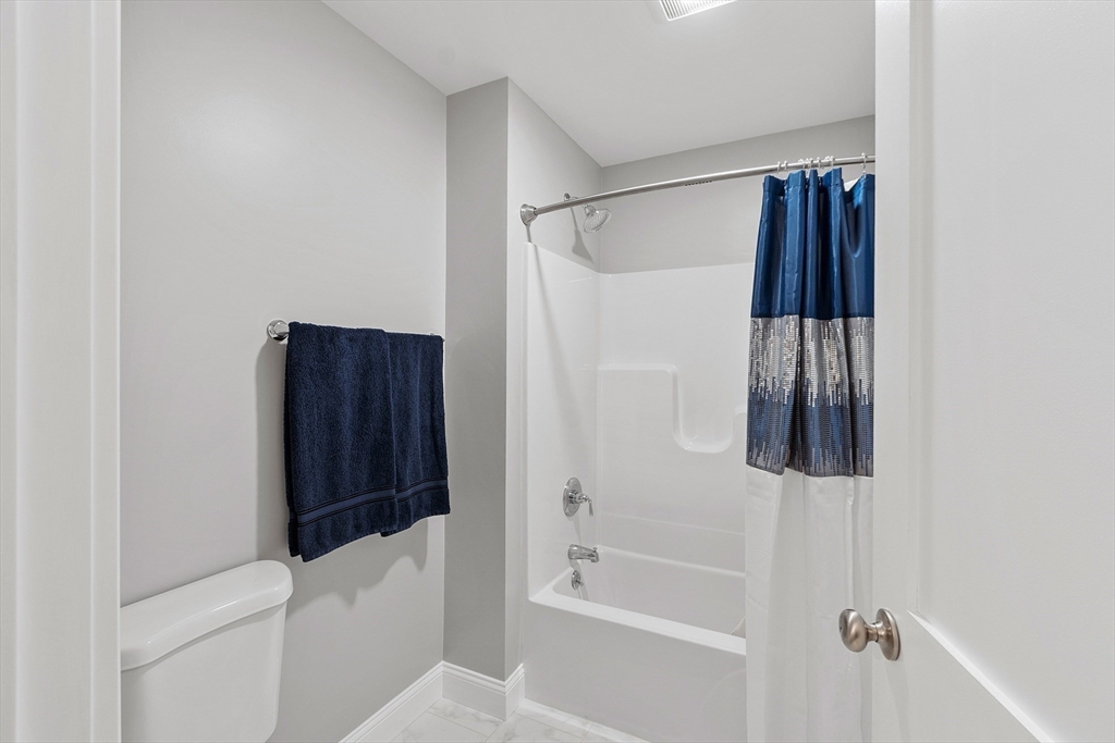 4 Scotch Pine Farm Way, Unit 1 Pepperell, MA 01463 - Photo 28 of 35 a bathroom with a shower curtain and a bathtub