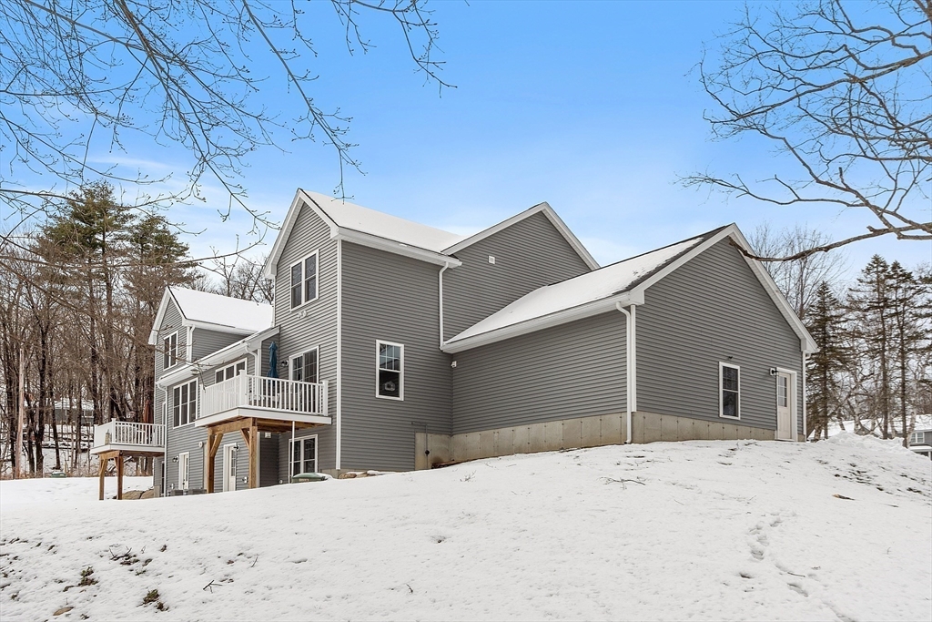 4 Scotch Pine Farm Way, Unit 1 Pepperell, MA 01463 - Photo 29 of 35 a view of a white house with a yard covered in snow