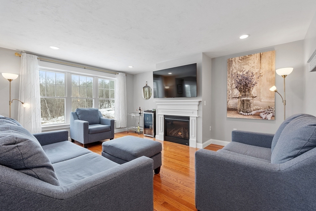 4 Scotch Pine Farm Way, Unit 1 Pepperell, MA 01463 - Photo 10 of 35 a living room with furniture a flat screen tv and a fireplace