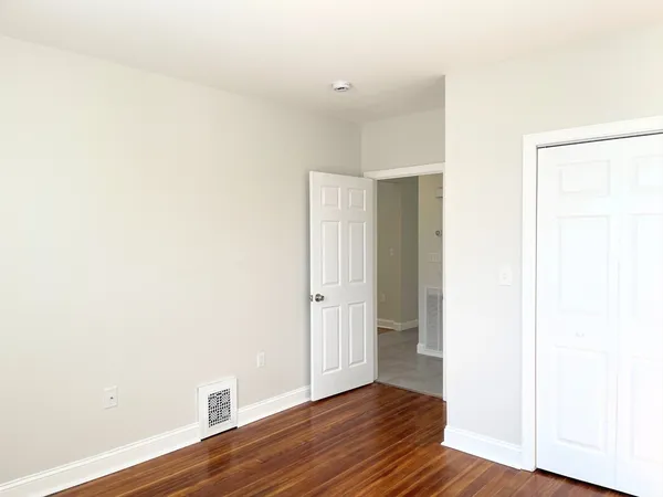 a view of an empty room with wooden floor