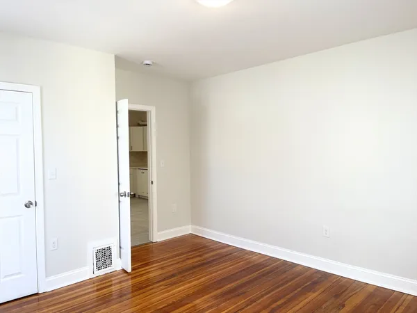 a view of an empty room with wooden floor