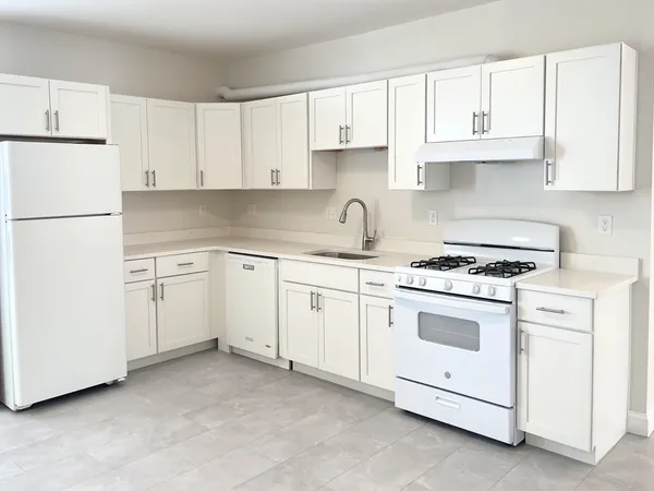 a kitchen with granite countertop white cabinets and white appliances