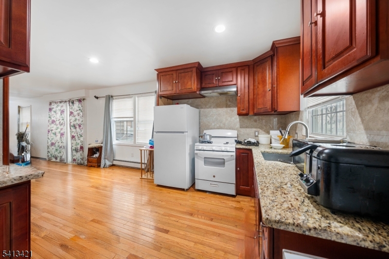 853 Rebecca Place Elizabeth, NJ 07201 - Photo 7 of 22 a kitchen with granite countertop a refrigerator stove and oven