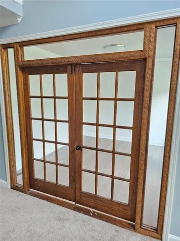 a view of an empty room with wooden floor and chandelier