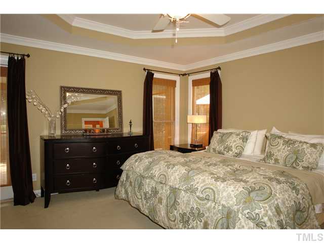 1317 Binley Place Raleigh, NC 27615 - Photo 14 of 25 a bedroom with a bed and a large mirror