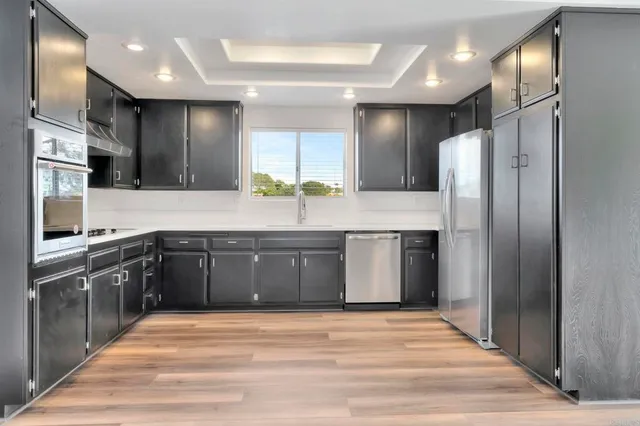 a kitchen with stainless steel appliances granite countertop a refrigerator and a sink