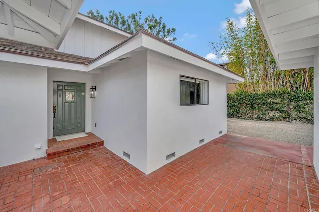 a view of a house with a yard and potted plants