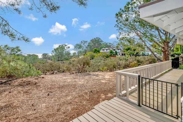 a view of balcony with wooden floor and fence