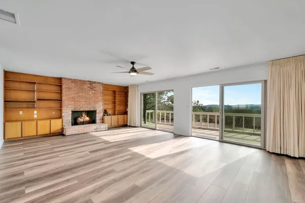 a view of a livingroom with a fireplace and wooden floor