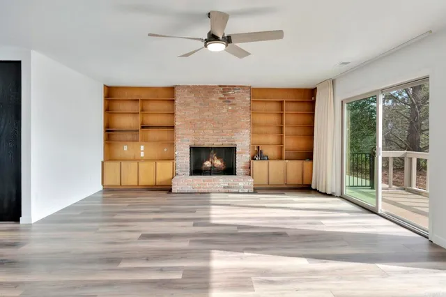 a view of an empty room with a fireplace and a window